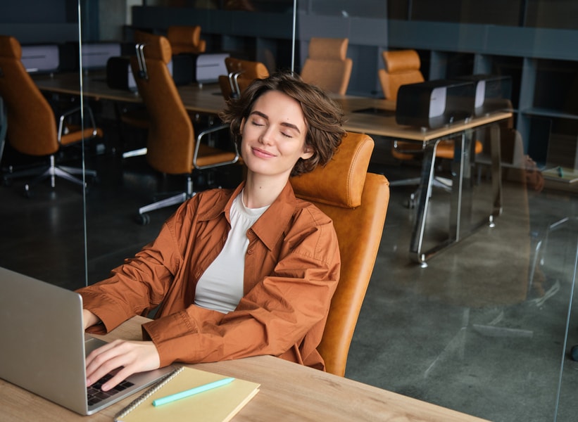 Image of working woman in office, digital nomad with laptop, programmer designing web page on computer, relaxing after day at workplace.
